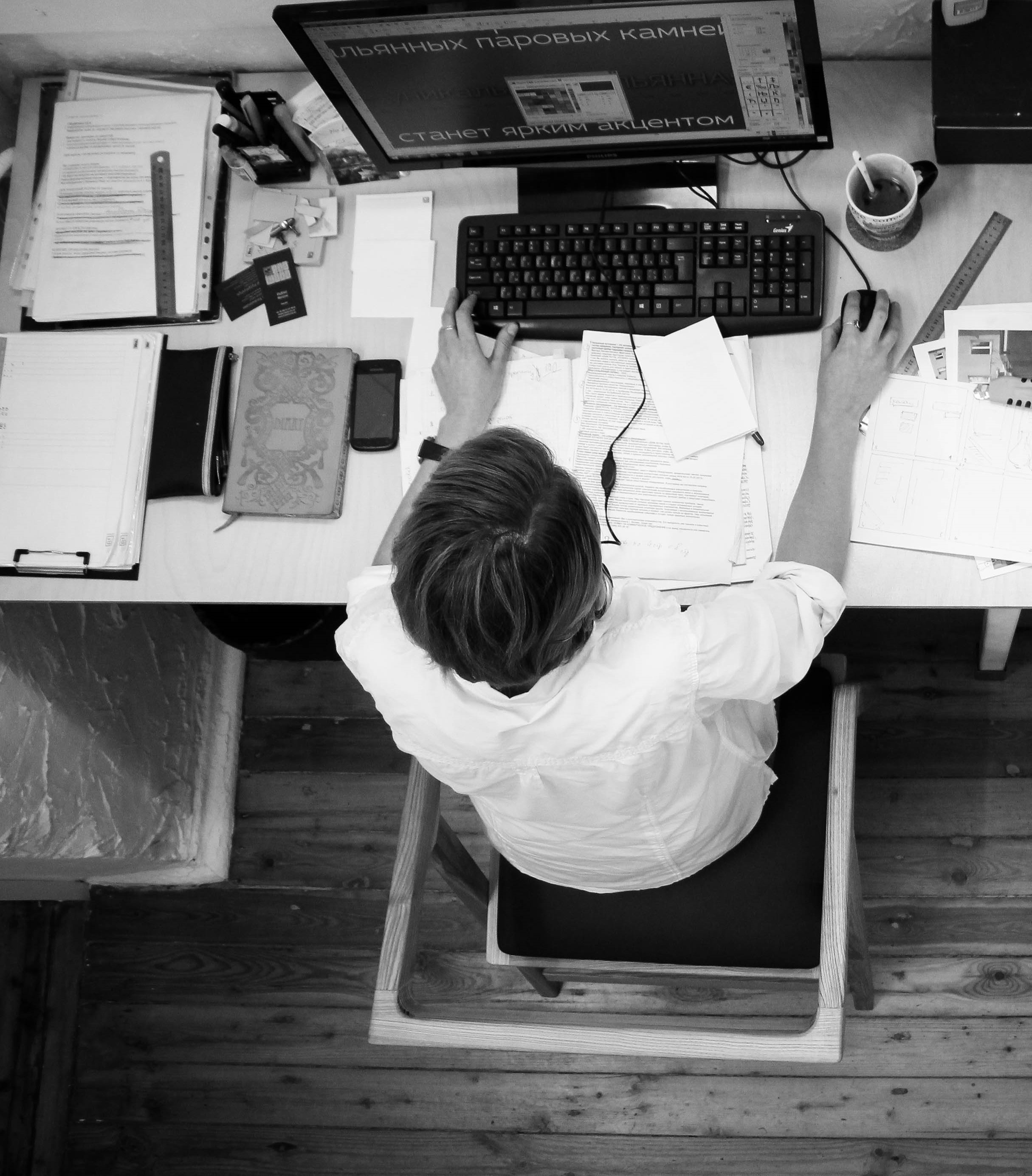 A Man Sitting At A Desk Using A Computer